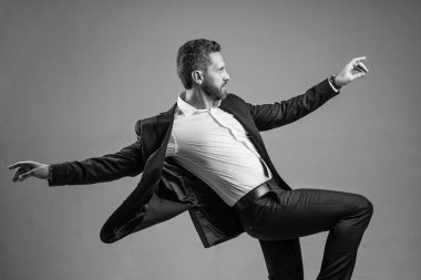 Elinden gelenin en iyisini yapıyorsun. Kişisel başarı hedefi. Gri arka planda dans eden adam. Kendine güvenen iş adamı resmi takım elbise giyer. Şirket partisini kutlayalım. Ofis hayatından zevk alıyorum. İş başarısı. mutluluk.