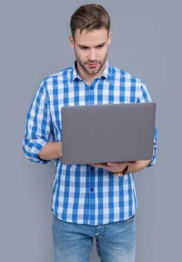 Bilgisayar programcısı stüdyosu. Dizüstü bilgisayar kullanan yazılım geliştiricisi. Dizüstü bilgisayarda yazan ciddi bir adam. Bilgisayar kullanıcısı gri renkte izole edildi.