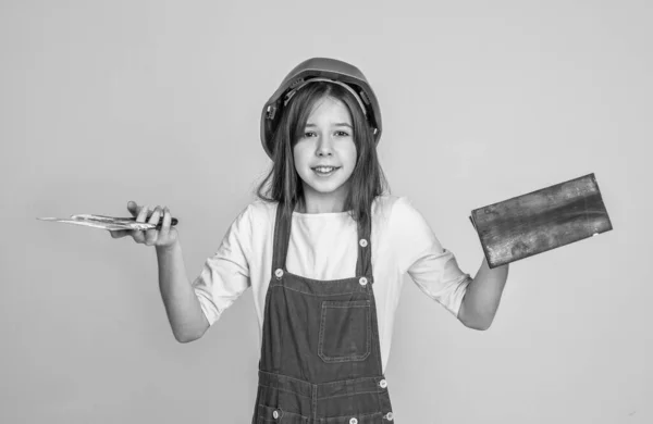 劳动节 穿着制服和头盔的少女 戴着硬礼帽的女建筑工人 建筑和施工 儿童建筑师工作者 工程师使用喷头工具 劳动孩子戴着安全帽 — 图库照片