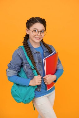 Çalışma alışkanlığım. Mutlu çocuk okula geri döndü. Küçük kız kitapları sarı arka planda tutuyor. Eğitim ve eğitim. Ev eğitimi ve eğitim. Özel ders. İyi çalışma alışkanlıkları. Bilginin başladığı yerde.