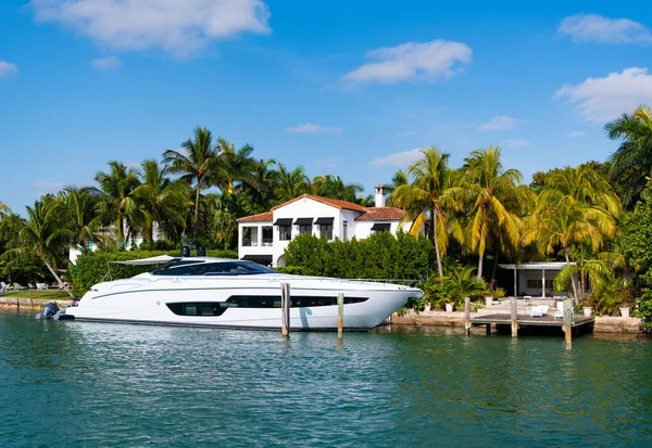 luxury private yacht in miami bay with palm trees.