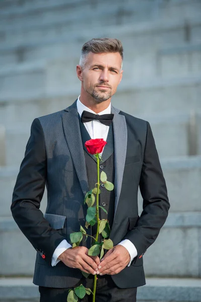 特殊场合的概念 一个浪漫的男人在特别的场合和玫瑰在一起 特定场合的室外燕尾服男 — 图库照片