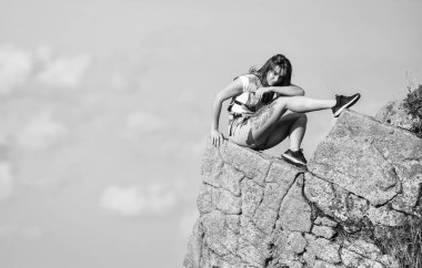 On edge of world. Woman sit on edge of cliff in high mountains blue sky background. Hiking peaceful moment. Enjoy the view. Tourist hiker girl relaxing edge cliff. Dangerous relax. Extreme concept.