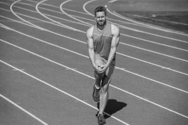 Erkek koşucu spor sonrası travma ve spor sakatlığı nedeniyle kaslarını esnetir..