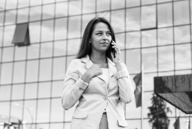 Neşeli, modaya uygun bir bayan telefonda konuşuyor. Başarılı kız akıllı telefon kullanır. İletişim. Kendine güvenen ve güzel bir kadın. İş kadını. Çevik iş. Formalite içinde kendine güvenen bir kadın.