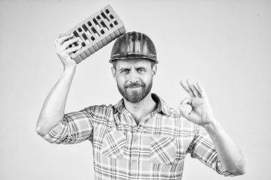 İşçi ya da işçi günü. Tuğlalı bir işçi. Adam işçi üniforması giyiyor. Kasklı yakışıklı bir müteahhit. Olgun adam kareli gömlek giyer. Profesyonel duvar ustası iyi bir jest yaptı. İnşaat mühendisi.