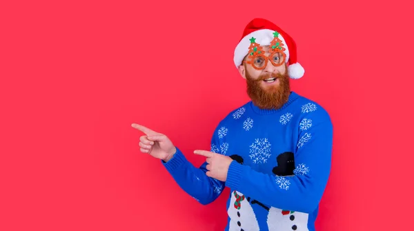 xmas holiday sale. man in xmas party glasses point finger on holiday sale. xmas man at holiday sale isolated on red background.