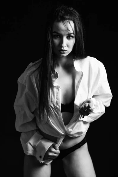シャツを着て 完璧な体の形だ ランジェリーの官能的なモデル 下着姿でセクシーな美少女 セクシーなモデルポーズ 黒を背景にセクシーな女性の肖像画 性的フェチコンセプト — ストック写真