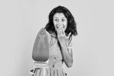 modern iron expelling hot steam. female ironing in laundry room. cheerful woman presenting product. girl launder delivery to customer. part time job occupation. happy beautiful lady use steaming iron.