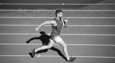 Maraton hızı. Koşucu. Koşu parkurunda enerjik bir adam. Sportif koşucu. Dayanıklılık. Spor ve dayanıklılık. Açık hava stadyum koşusu. Beden eğitimi. Atletik koşucu. meydan okuma ve rekabet.