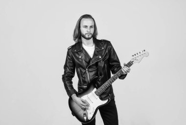Deri ceketli sakallı rockçı. Uzun saçlı bir adam elektro gitar çalıyor. Rock müzik tarzı. müzisyen gitarist. Rock müziğini ustaca çalmak. Modaya uygun çılgın adam. string müzik enstrümanı.