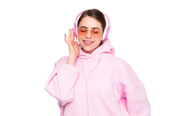 분홍색 후드를 소녀는 헤드폰을 헤드폰으로 음악을 듣기를 즐긴다 — 스톡 사진