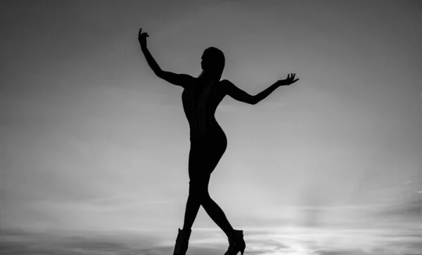 Rise of inspiration. Woman silhouette on evening sky. Inspirational figure. Inspiration. Dance girl in dusk. Dancing silhouette. Ballet dancer in twilight. Female performer.