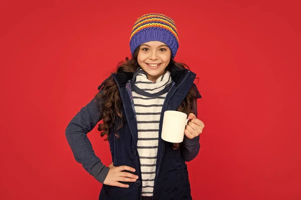 パッパーウエストコートと帽子の正の子供 10代の女の子が赤い背景に温かいお茶を飲む コーヒーカップの子供の肖像画 ココアとミルクを飲み — ストック写真