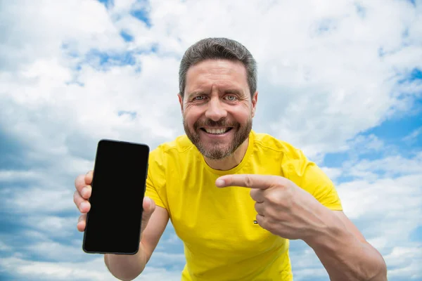 Hombre Sonriente Que Presenta Pantalla Del Teléfono Inteligente Con Espacio — Foto de Stock