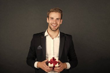 İş adamı kılığındaki neşeli, zarif adam sevgililer günü hediyesi tut, sevgilim ol..