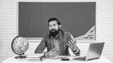 Profesör ya da öğretmen okul masasında oturuyor, eğitim....