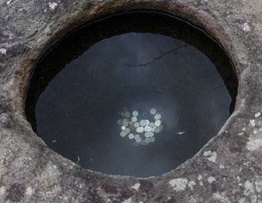 Altında bozuk paralar olan antik taş kuyusu. Arzu dolu. Bellekte Sikke.