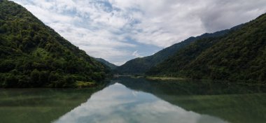 Dağlarla çevrili bir göl. Kafkas dağları. Sudaki yansıma.