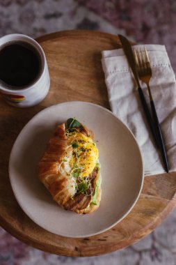 Pastırmalı omlet, mikro yeşil lahanalar, kruvasan püresi. Amerikan kahvesi. Kahve masası. Sarı, yeşil renkler. Süslü kahvaltı ya da brunch. Huysuz yemek fotoğrafçılığı. Taze yemek.