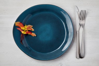 El yapımı zümrüt seramik tabak ve çatal bıçaklı akçaağaç tohumu ikizleri.