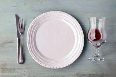 Beyaz tabak, bir bardak şarap, egzotik baharatlar ve açık mavi ahşap masada meyveler. Düz yatıyordu