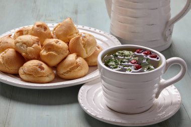 Kremalı profiterol ve bir fincan bitkisel çay.