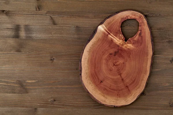 Винтажная распильная доска из дерева на тёмном деревянном столе — стоковое фото
