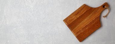 Gri beton bir masada kahverengi tahta kesme tahtası