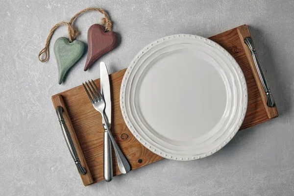 Prázdný bílý talíř s příbory na dřevěném podnosu — Stock fotografie