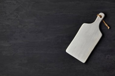 Koyu beton bir masada beyaz tahta kesme tahtası.