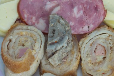 Bir dilim dilimlenmiş köfte ve bir parça sosis yakın plan..