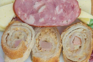 Üç dilim dilimlenmiş köfte ve bir parça sosis.