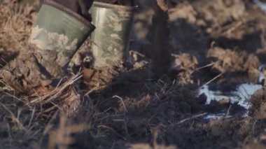 Çamurda kürekle çamur kazan bir adam..