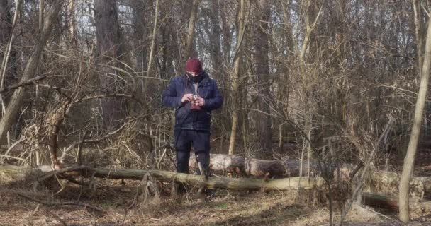 森の保護マスクの男が古いフィルムカメラで写真を撮る — ストック動画