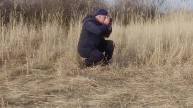 Fotoğrafçı filmi geriye sarar ve doğanın fotoğraflarını çeker..