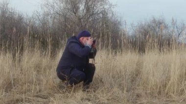  Yüzünde koruyucu maske olan bir gezgin-fotoğrafçı bir film kamerasında doğanın fotoğraflarını çekiyor..