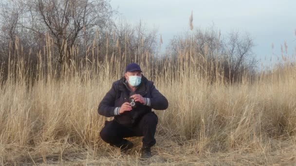 Podróżnik Fotograf Masce Ochronnej Twarzy Kuca Fotografuje Naturę Dwuobiektywową Kamerą — Wideo stockowe