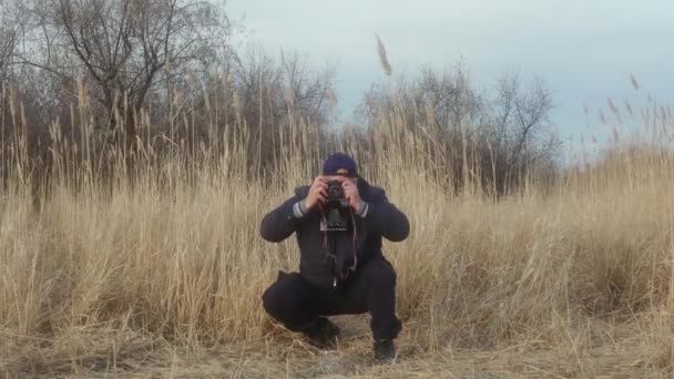 Cahul 摩尔多瓦 2021 一位戴着保护膜的旅行摄影师 蹲在地上 用复古胶卷照相机拍摄野生动物 — 图库视频影像