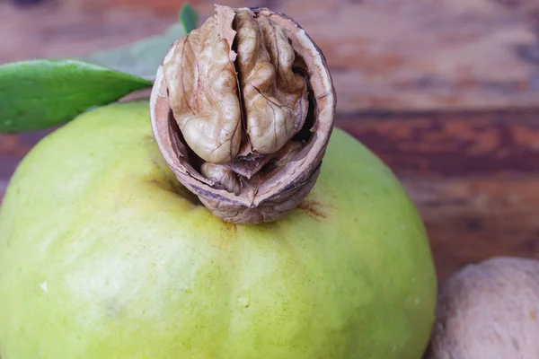 half walnut with kernel on fresh quince close-up.