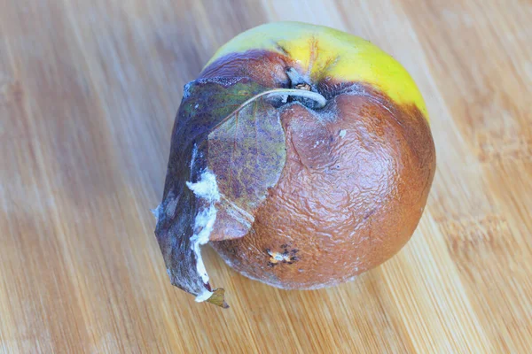Ahşap bir tahtada çürümüş ayva, yakın plan.