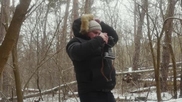 Ein Mann Verschneiten Wald Fotografiert Die Natur Mit Einer Vintage — Stockvideo