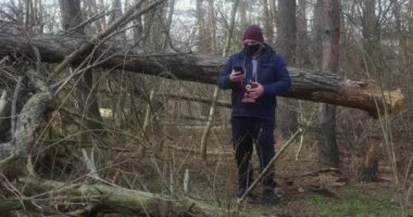Düşen bir çam ağacının arka planında eski bir film kamerası olan turist fotoğrafçısı selfie çekiyor.
