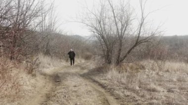 Bir adam yolda yürürken cep telefonuyla konuşur..