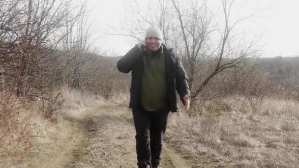 Szczęśliwy Człowiek Spaceruje Rozmawia Przez Telefon Komórkowy Naturze Wzdłuż Szlaku — Wideo stockowe