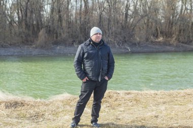  Nehrin kıyısında ormanı olan bir adamın tam boy portresi..