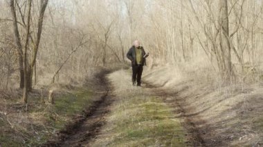 Ormanda cep telefonuyla konuşan bir adam.