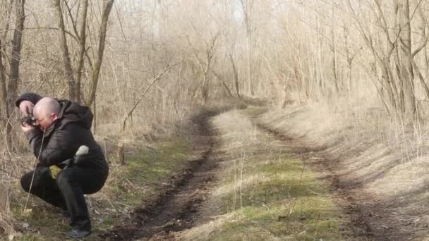 Fotógrafo Sendero Forestal Toma Fotos Ramas Una Cámara Cine Retro — Vídeo de stock