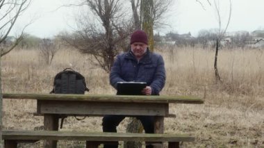  Tabletli bir adam masada oturuyor..