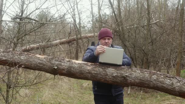 Freelancer Het Bos Typt Een Laptop Gemonteerd Een Dennenboom Het — Stockvideo